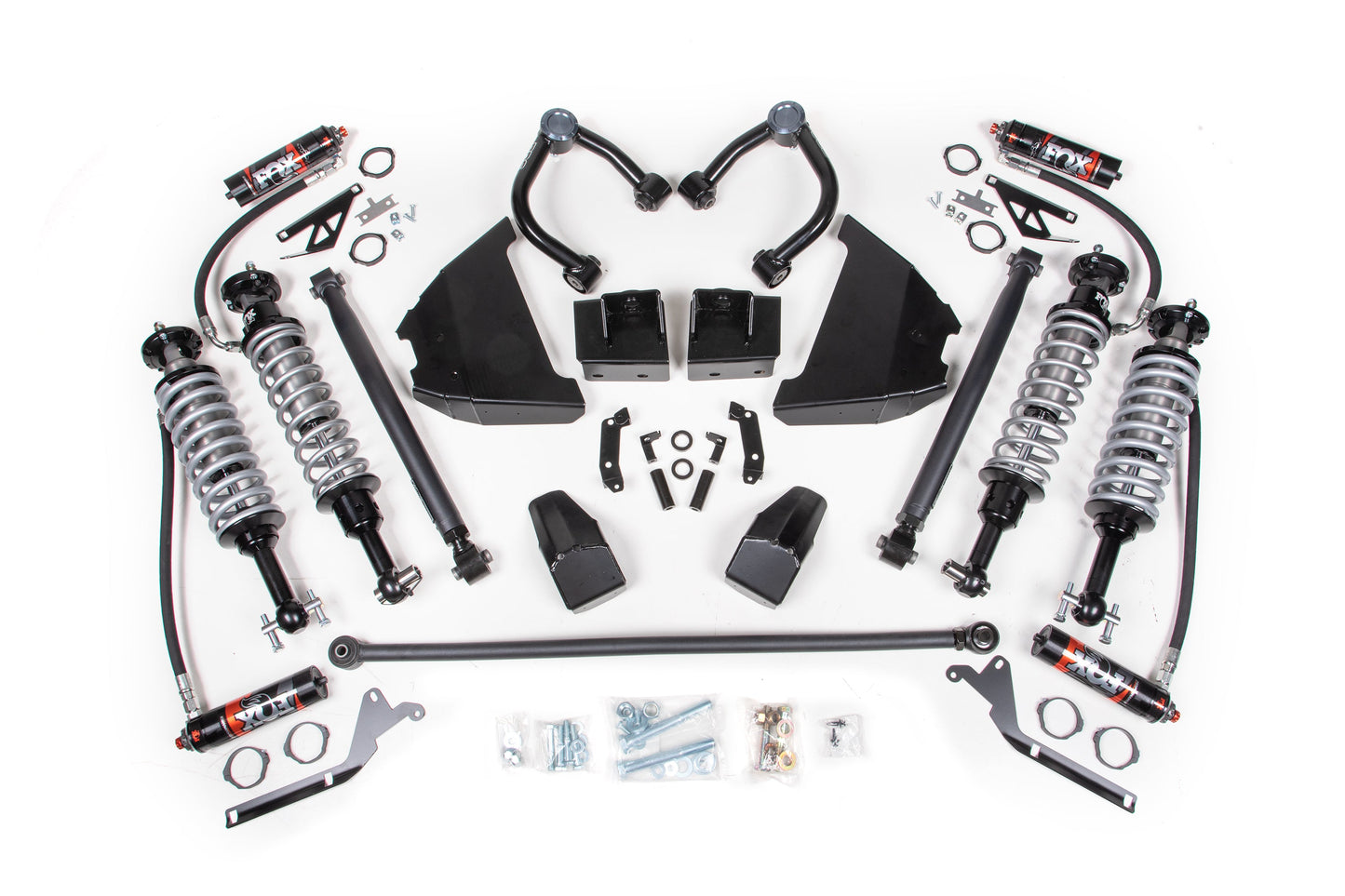 A neatly arranged 4 Inch Lift Suspension Package - KOH Edition by BDS, featuring FOX 2.5 Performance Elite coil-over shocks, springs, upper control arms, and various mounting hardware components displayed on a white background. This suspension kit for the Ford Bronco (21-23) includes coilovers, spacers, bolts, brackets, and bushings.
